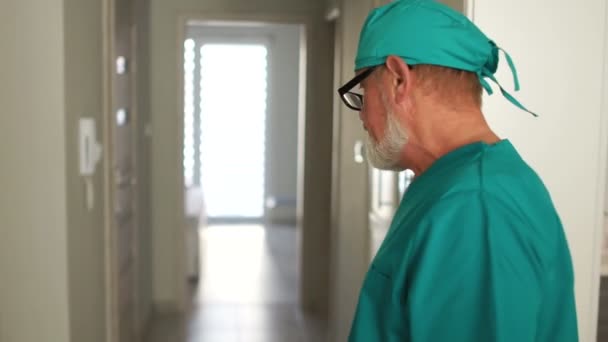 Pracownicy kliniki podczas pracy. Siwy mężczyzna z brodą i młoda kobieta w okularach — Wideo stockowe