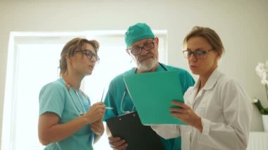 Doktor adam ve iki genç stajyer kadın. Hastanede genç doktorların eğitimi. Tıbbi uygulama