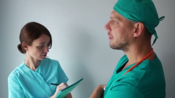 El médico y el asistente médico discuten temas de trabajo. Hombre enojado, conversación emocional, medicina y salud — Vídeo de stock