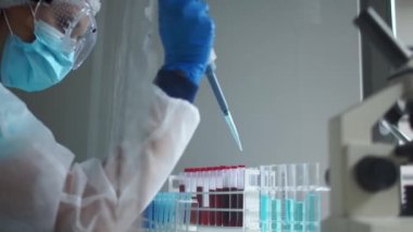 Laboratuvar asistanı, koronavirüsü teşhis etmek için laboratuvar testleri için pipet makinesi kullanır. Bir araştırmacı, Covid-19 Coronavirüs enfeksiyonunun kan örneklerini inceliyor.