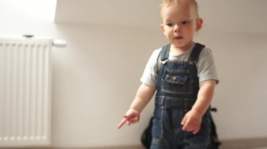 Evde tatlı bir çocuk yerde oynuyor, iki yaşında bir çocuk ellerini açıyor, negatif jest, saklambaç, anaokulu.