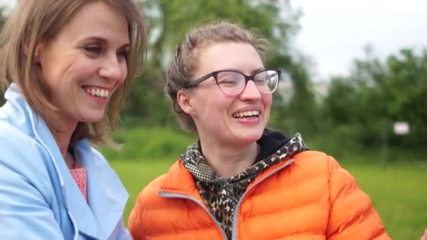 Twee jonge vrouwen blogger poseren voor een smartphone camera. Vrouwen schieten video voor vlog met behulp van smartphone en stabilisator — Stockvideo