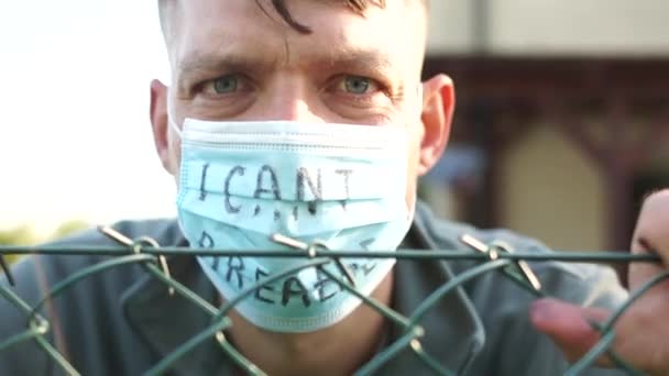 Ik krijg geen lucht. Gemaskerde man met een inscriptie achter tralies, angstblik. Massaprotesten in de VS. Protest en solidariteit — Stockvideo
