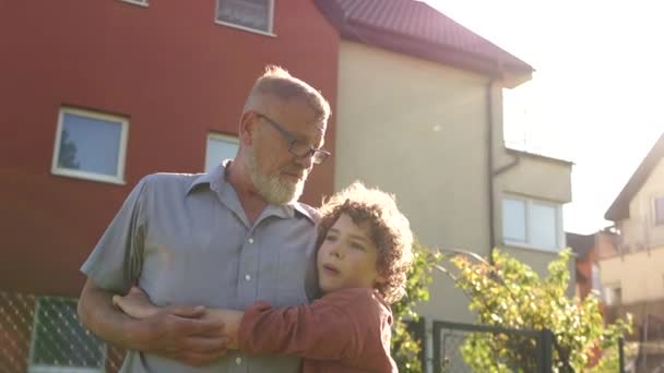 Closeup portrait of a mature man hugging his late son. Happy fatherhood, fathers day. Curly child, a man wearing optical glasses. Colorful sunset Royalty Free Stock Footage