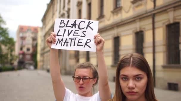 Lidé protestují proti rasismu a netoleranci. Hromadné protesty, studenti v ulicích města drží plakáty s nápisem jsme stejní, nemůžu dýchat, na černých životech záleží — Stock video
