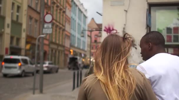 Schöne gemischte Rasse Paar läuft entlang einer Straße der Stadt. Kaukasische Frau und schwarzer Mann, verliebtes Studentenpaar, Valentinstag — Stockvideo