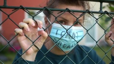 Protestolar ve ayaklanmalar, George Floyd 'un Mineapolis' te ölümüne tepki. Genç beyaz kadın parmaklıkların arkasında, maske yazısıyla nefes alamıyorum. Siyah Yaşamlar Maddesi