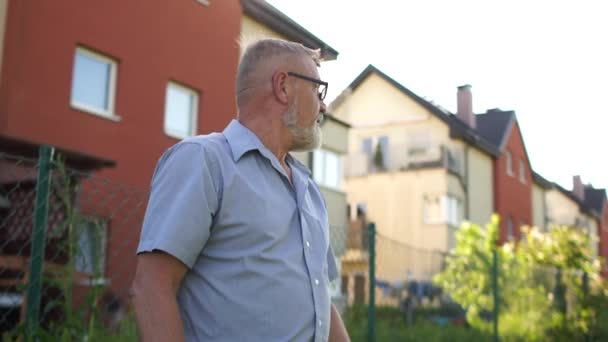 Lockiger Teenager rennt, um einen grauhaarigen älteren Mann zu umarmen. Großvater und Enkel trafen sich während der Sommerferien, Treffen nach der Quarantäne, nach der Quarantäne — Stockvideo