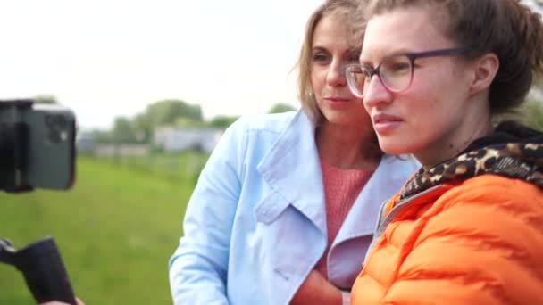 Twee jonge mooie vrouwen maken video-inhoud voor hun vlog outdoor. Sociale netwerken en vlogging — Stockvideo