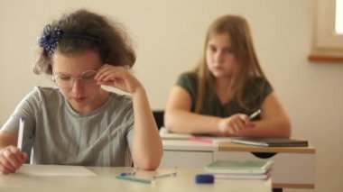 Son masadaki liseli kız arkadaşına bir kağıt fırlattı. Iskaladı. Karantina sonrası normal okul rutini, okula dönmek. Sınıf arkadaşları sınıfta.