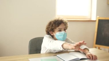 Lisedeki sınıftan bir ders. Sınıftaki maskeli çocuklar, kız bir erkeğe bir kalem verir. Karantina sonrası yaşam, okula dönüş, yeni kurallar