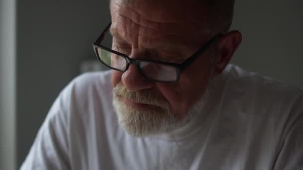 Close portrait of an unemployed mature man with glasses. Counts the remaining money to pay bills. World economic crisis concept, falling income and living standards. Social problems — Stock Video