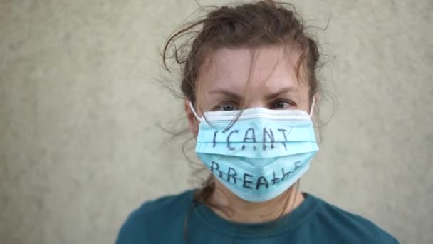 Dicht portret van een droevige vrouw in een masker met de inscriptie die ik niet kan ademen. Meisje rukt het masker af, zwarte levens doen ertoe. — Stockvideo