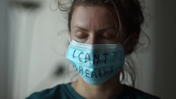 Dicht portret van een droevige vrouw in een masker met de inscriptie die ik niet kan ademen. Massale protesten in de VS en Europa tegen geweld en racisme. Zwarte levens zijn belangrijk. — Stockvideo
