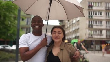 Yağmur yağarken şehir caddesinde koşan güzel melez bir çift. Elinde şemsiye tutan siyah bir adam. Beyaz kadın ve siyah erkek, öğrenciler aşık, sevgililer günü