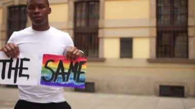 Irkçılığa ve hoşgörüsüzlüğe karşı protesto. Afro-Amerikalı bir adam ve beyaz bir kadın, birbirimize benzediğimizi ve LGBT sembolleri taşıdığımızı söyleyen bir poster tutuyorlar.
