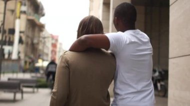 Arkadan bak. Şehir caddesinde koşan güzel melez bir çift. Beyaz kadın ve siyah erkek, öğrenciler aşık, sevgililer günü