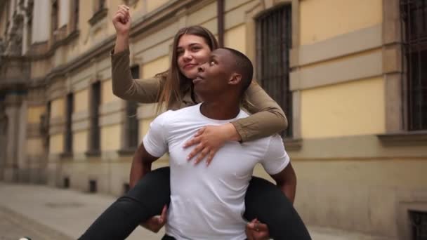 Mladý zamilovaný mezirasový pár, Valentýn, černobílý pár. Černoch a běloška se baví na ulici. — Stock video