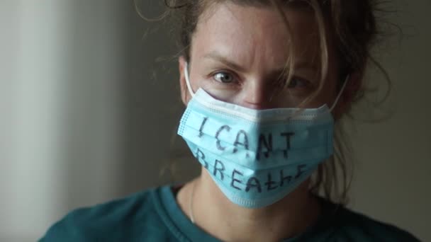 Blízký dramatický portrét mladé bělošky v lékařské masce s nápisem Nemůžu dýchat. Hnutí BLM, na černých životech záleží, podpora masových protestů proti rasismu — Stock video