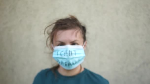 Açık havada, içinde nefes alamadığım yazıyla birlikte tıbbi maskeli bir kızın portresi. Şiddete ve ırkçılığa karşı protesto — Stok video