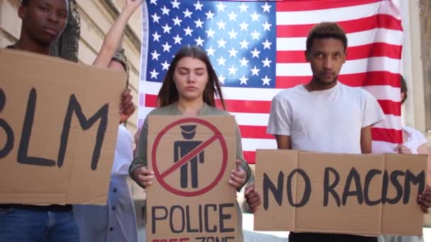 Unga studenter protesterar mot rasism mot bakgrund av den amerikanska flaggan. Svarta liv spelar roll. Amerikanska protester — Stockvideo