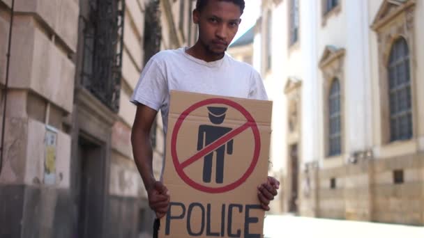 Protestas masivas en Estados Unidos. Estudiante afroamericano protesta por la violencia policial y el racismo. Retrato al aire libre de un joven negro con un cartel policial zona libre — Vídeos de Stock