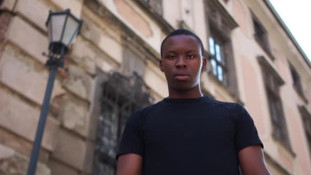 Portet eines jungen schwarzen Mannes. Ein ernster Typ hebt die geballte Faust. Protest gegen Rassismus — Stockvideo