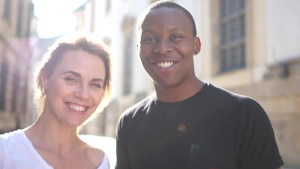 Una pareja interracial encantadora. Hombre africano y mujer europea. Cerrar retrato al aire libre con destello solar — Vídeo de stock