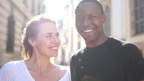 Preciosa pareja multirracial caminando por la ciudad. Rayos de sol retrato hombre negro y mujer blanca. Amor contra el racismo — Vídeo de stock