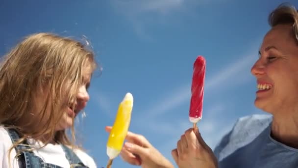 青い空に向かって見つめ合う棒にアイスクリームをかけた母と娘。面白いビデオ、母の日、幸せな家族の概念。娘ステンドグラスお母さんの鼻とともにアイスクリーム — ストック動画