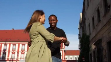 Siyah adam ve beyaz kadın sokakta dans ediyorlar. Şehir caddesinde dans eden güzel bir ırklar arası çift. Salsa ve Latin Amerika dansları, sosyal danslar