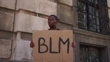 Amerika 'daki protestolar. Afro-Amerikalı bir adam elinde BLM yazılı bir poster tutuyor. Siyah hayatlar önemlidir, açık hava portresi.