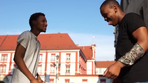 Dos jóvenes estudiantes afroamericanos bailan en una calle de una ciudad europea. Concepto de inmigración e intercambio estudiantil — Vídeos de Stock