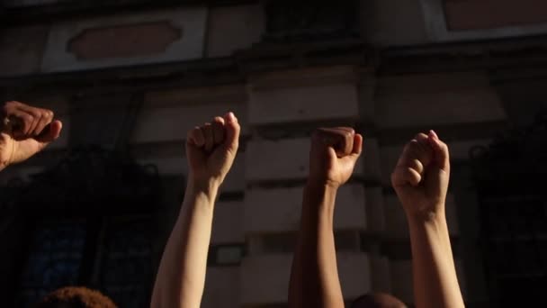 Levantó los puños contra el telón de fondo de una muralla. La gente está cantando consignas. La protesta contra el racismo. Protestas en Estados Unidos — Vídeos de Stock