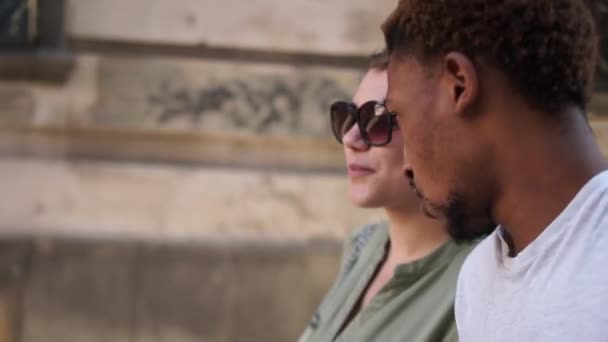 Preciosa pareja multirracial caminando por la ciudad. Rayos de sol retrato hombre negro y mujer blanca. Amor contra el racismo — Vídeos de Stock