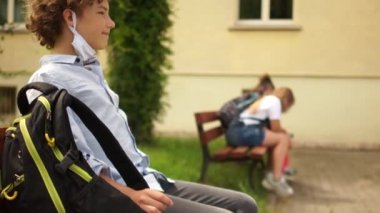 Maskeli bir çocuk okuldan ayrılıp okul bahçesindeki bankta oturuyor. Sınıf arkadaşlarını uzaktan selamlıyor. Maskeyi ve tabakları özgürce çıkartıyor. Karantinadan sonra okula, sosyal mesafeye