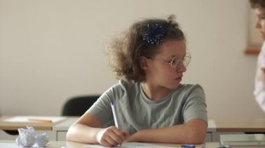 Eğitim, ilkokul, öğrenme ve insan konsepti. Sınıfta elinde kalem ve not defteri olan bir grup öğrenci. Okula geri dön.