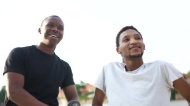 İki siyah öğrenci eğleniyor. Şehir dışından yakın plan portre. Mutlu insanlar, eşitlik ve kardeşlik kavramı, seyahat ve öğrenci arkadaşlığı