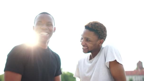 Concept d'égalité et de fraternité. Rencontre de deux amis afro-américains. Salutation poignée de main et câlin. Portret extérieur de deux étudiants noirs — Video