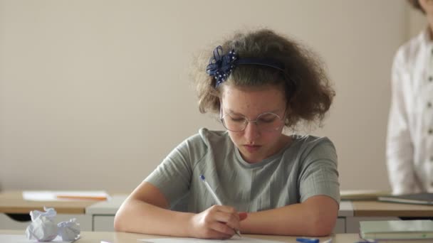 Adolescentes en la escuela durante la lección. La niña dibuja en el papel, la colegiala se aburre durante la lección, de vuelta a la escuela — Vídeos de Stock