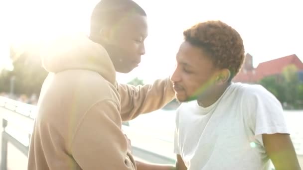 Hermandad e igualdad. Dos amigos negros, dos estudiantes afroamericanos se saludan con los puños. Cerrar retrato al aire libre — Vídeos de Stock