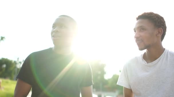 Dos negros, retrato de ciudad al aire libre. Retrato de cerca de dos jóvenes amistosos, estudiantes felices. Encuentro de dos estudiantes afroamericanos, saludo de bienvenida y abrazos — Vídeos de Stock