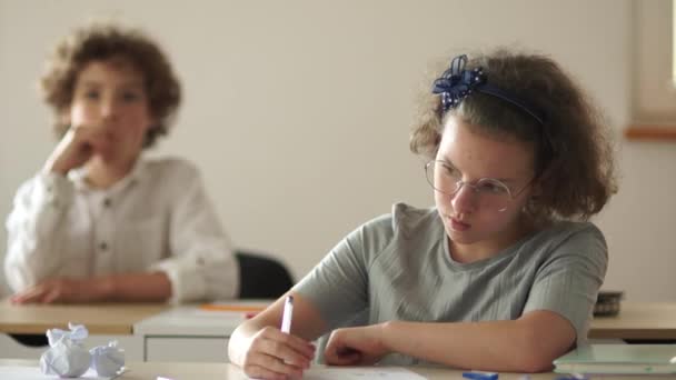 Mitschüler, ein Junge und ein Mädchen sitzen während des Unterrichts an ihren Schreibtischen. Zurück in die Schule, neues Schuljahr — Stockvideo