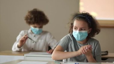 Maskeli okullu çocuklar. Okuluna geri dön. Kız notu oğlana verir. Okulları yeniden aç