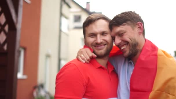 Gay pár. Dva mladí muži se objímají a drží vlajku duhy LGBT. Práva gayů, manželství gayů — Stock video