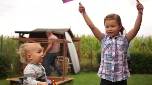 Barn, pojke och flicka, leker på gården med regnbåge hbt-flaggor. HBTQ-samfundet, adoption av barn, tolerans — Stockvideo