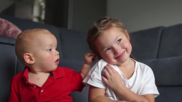 Beau petit garçon et fille applaudissent leurs mains et sourient. Enfant embrassant sa petite sœur, frère et sœur, concept d'enfance heureuse — Video