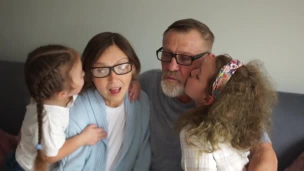 Opa en oma lachen en hebben plezier met twee kleindochters. Gelukkige grootouders en twee kleindochters. Sluiten Indoor portret. — Stockvideo