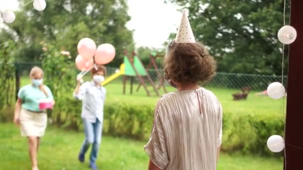 Distance sociale. Salutation sans contact à la fête d'anniversaire. Anniversaire fille accepte félicitations dans un masque pendant la quarantaine de coronavirus covid-19 — Video