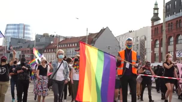 Wroclaw, Polonia - 3 de octubre de 2020. Marcha por la igualdad en Polonia. Muchas personas caminando en el desfile gay lgbt con banderas coloridas de arco iris en una calle de un centro de la ciudad — Vídeos de Stock